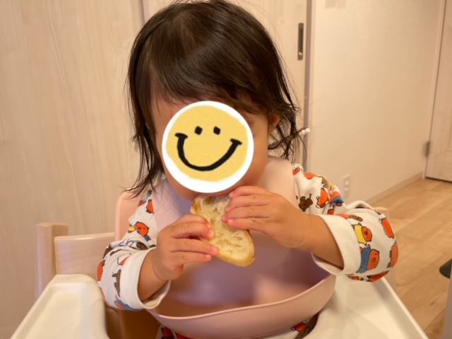 1歳のむすめがフランスパンを持っているところの写真