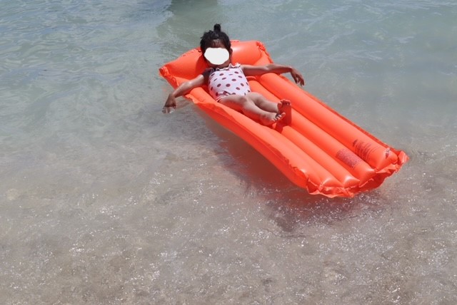 ワイキキビーチでリラックスする娘の写真